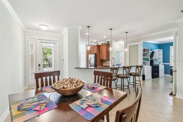 dining room featuring light tile patterned floors, baseboards, visible vents, and crown molding