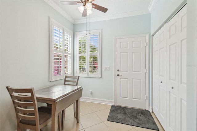 dining room featuring baseboards, ornamental molding, a ceiling fan, and light tile patterned flooring