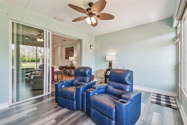 living area with ceiling fan, wood finished floors, and baseboards