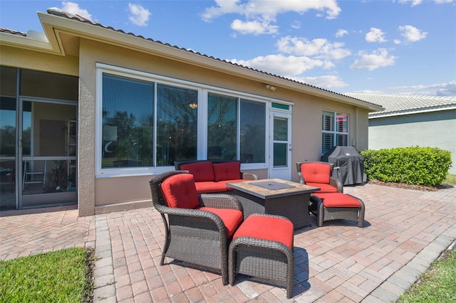 view of patio / terrace with an outdoor fire pit, a sunroom, and grilling area