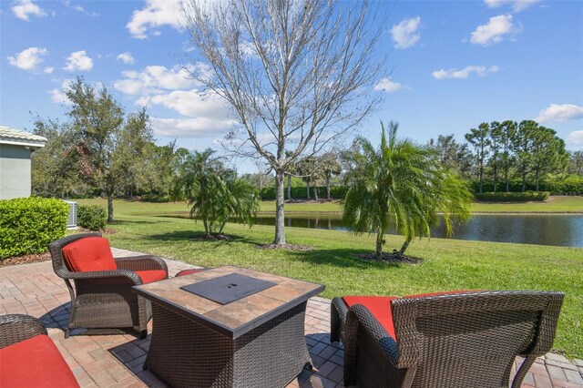 view of patio / terrace with a fire pit and a water view