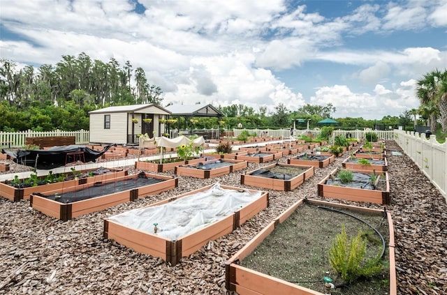 view of yard with an outdoor structure, fence, and a garden