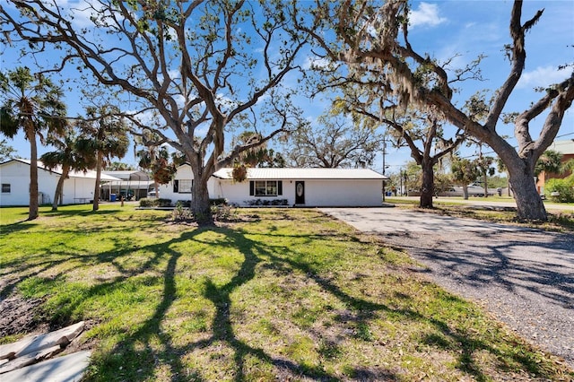 single story home with driveway and a front lawn