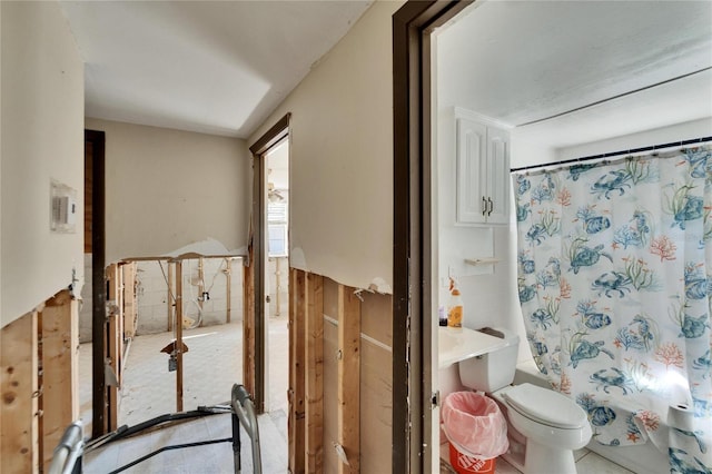 bathroom featuring shower / tub combo and toilet