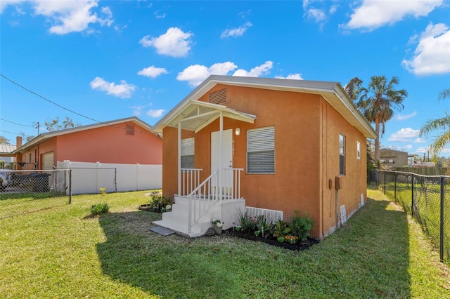 rear view of property featuring a garage, a yard, a fenced backyard, and stucco siding