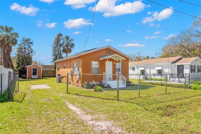 exterior space with an outbuilding, a fenced front yard, a storage shed, a yard, and stucco siding