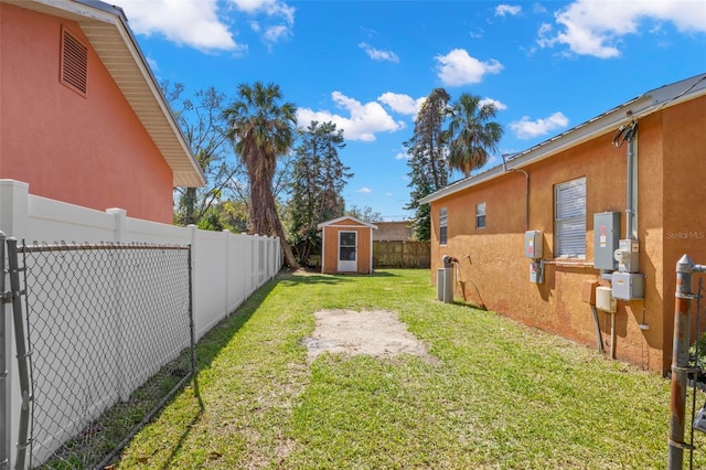 view of yard with a storage unit, an outdoor structure, and a fenced backyard