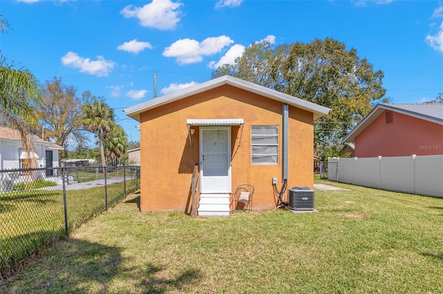 view of outbuilding with entry steps, a fenced backyard, and central AC unit