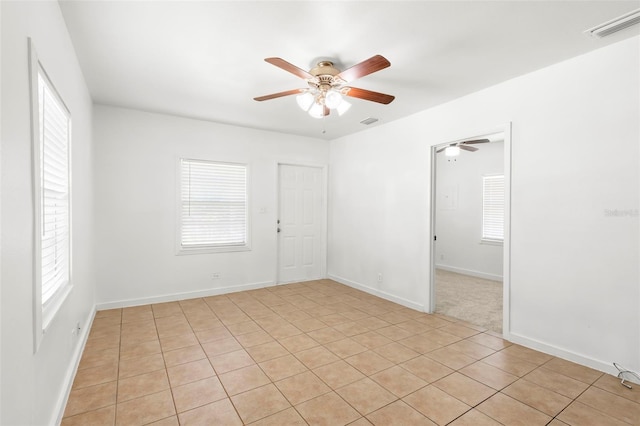 unfurnished room featuring a wealth of natural light, visible vents, and ceiling fan