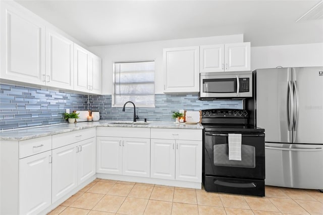 kitchen featuring appliances with stainless steel finishes, decorative backsplash, a sink, and light tile patterned flooring