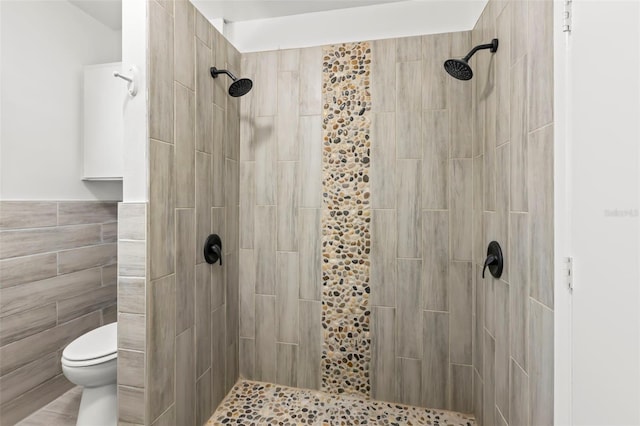 bathroom featuring a tile shower, tile walls, and toilet