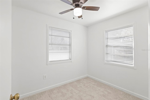 spare room featuring plenty of natural light, carpet, baseboards, and ceiling fan