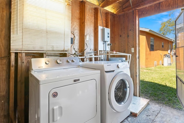 laundry room with laundry area, separate washer and dryer, and wooden walls