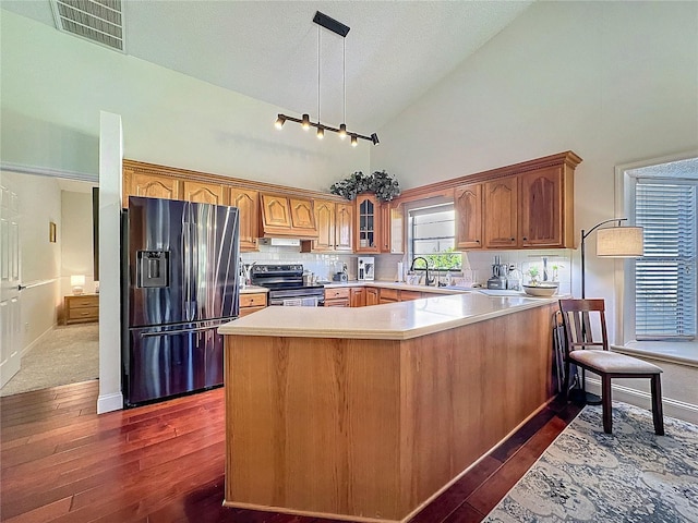 kitchen featuring visible vents, refrigerator with ice dispenser, electric stove, light countertops, and glass insert cabinets