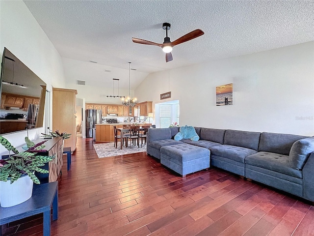 living room featuring vaulted ceiling, visible vents, dark wood finished floors, and ceiling fan with notable chandelier