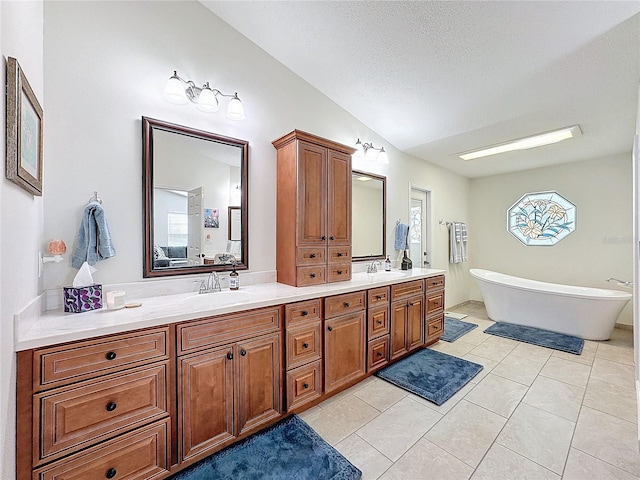 bathroom featuring a freestanding bath, double vanity, tile patterned flooring, and a sink