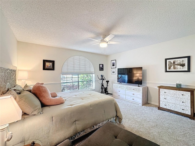 carpeted bedroom with ceiling fan and a textured ceiling