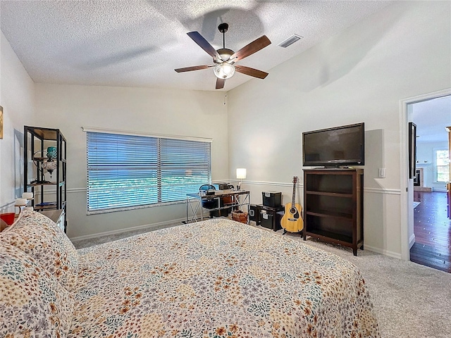 bedroom with a ceiling fan, visible vents, a textured ceiling, and carpet flooring