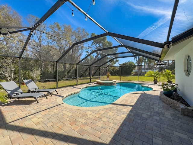 view of pool with glass enclosure, a patio area, and a pool with connected hot tub