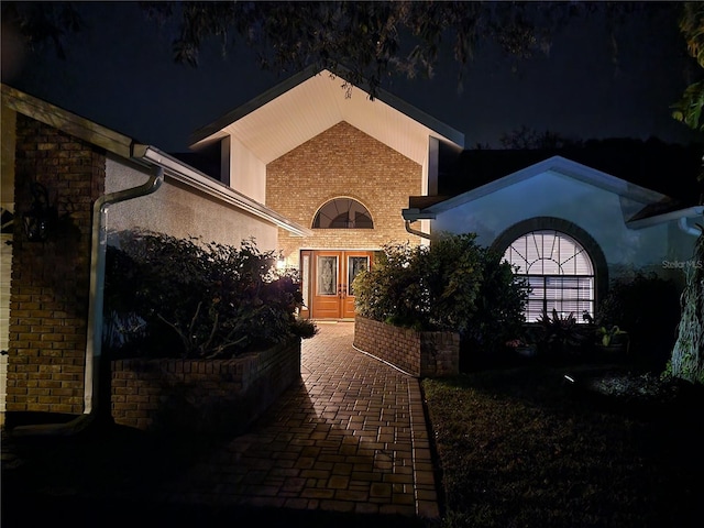 exterior space with french doors and brick siding