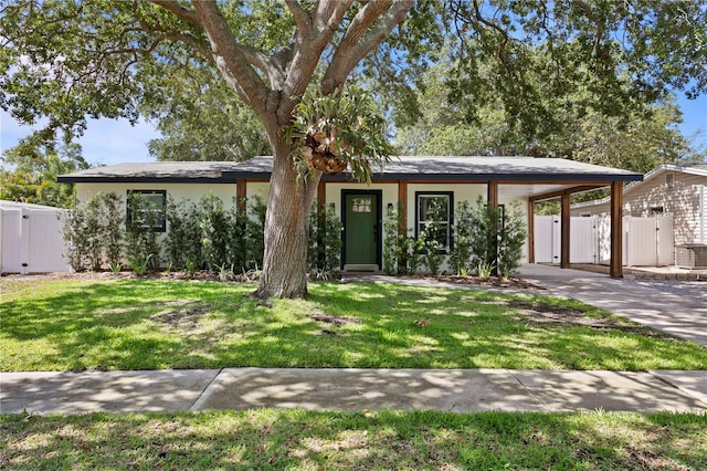 view of front facade featuring a carport, a gate, driveway, and stucco siding