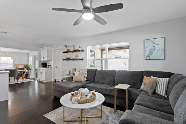 living room featuring dark wood finished floors and a ceiling fan