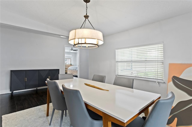 dining room with dark wood finished floors, a chandelier, and baseboards