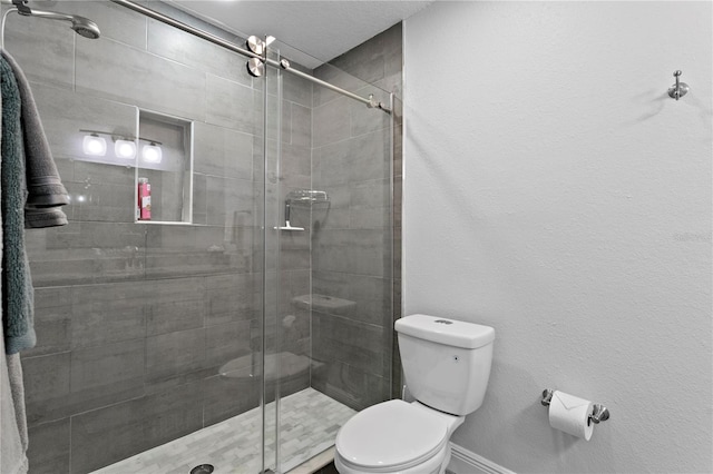 bathroom featuring toilet, a shower stall, and baseboards