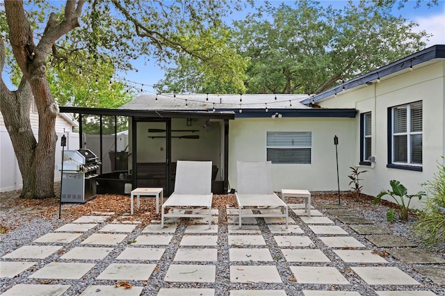 rear view of house featuring a patio area, stucco siding, and fence