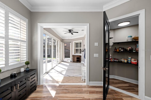 entryway featuring baseboards, ceiling fan, light wood finished floors, and crown molding