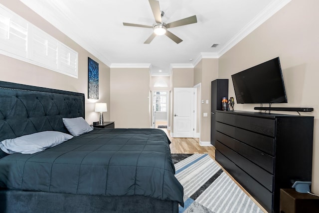 bedroom featuring light wood finished floors, visible vents, baseboards, ceiling fan, and ornamental molding