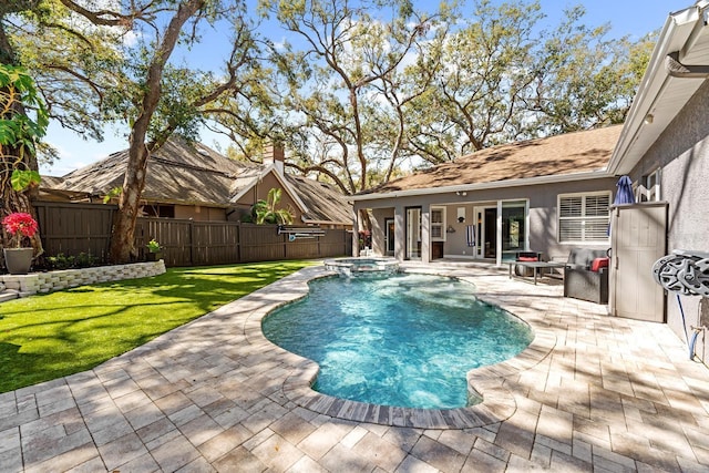 view of pool with a patio area, a pool with connected hot tub, fence, and a yard