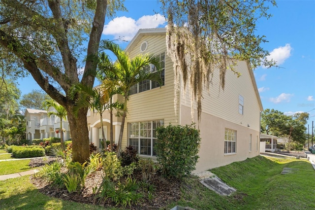 view of side of property with a yard and stucco siding