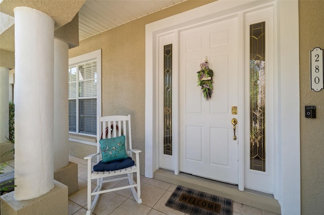 entrance to property featuring a porch and stucco siding