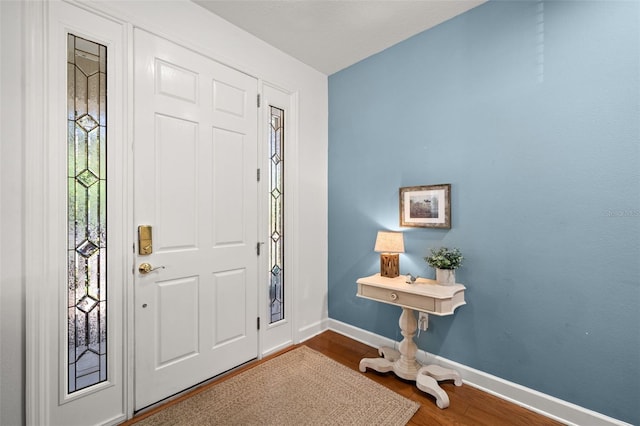 entrance foyer with baseboards and wood finished floors