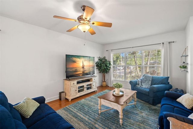 living area with ceiling fan, baseboards, and wood finished floors