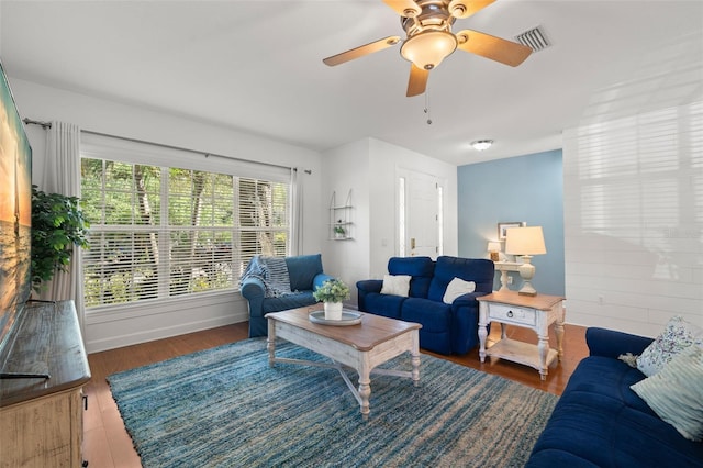 living area featuring wood finished floors, visible vents, and baseboards