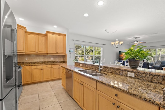 kitchen featuring stainless steel appliances, plenty of natural light, a sink, and light tile patterned floors