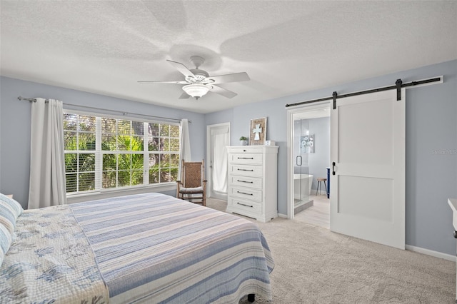 bedroom with a textured ceiling, a barn door, light carpet, a ceiling fan, and baseboards