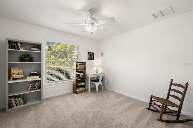 living area featuring baseboards, carpet, visible vents, and a ceiling fan