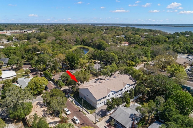 drone / aerial view featuring a water view and a wooded view