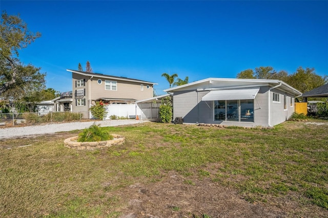 back of property with fence and a yard