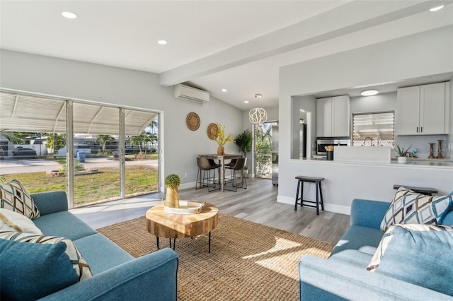 living room with a wall unit AC, light wood-style flooring, baseboards, and recessed lighting