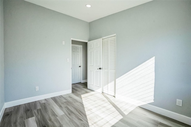 spare room with recessed lighting, baseboards, and wood finished floors