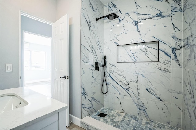 full bath with a marble finish shower and vanity