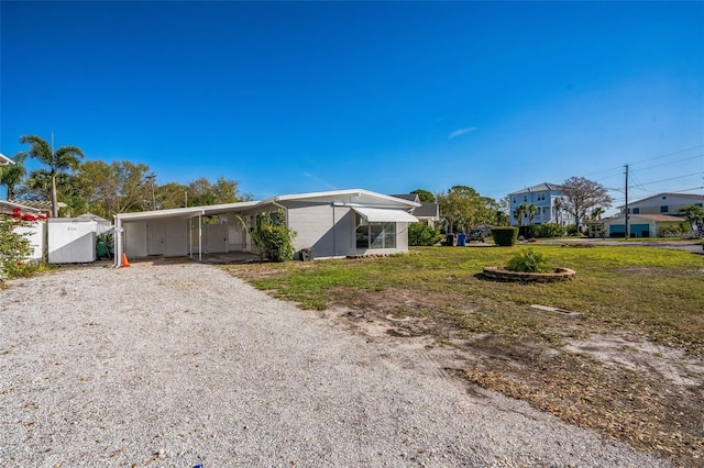 exterior space with driveway, a front lawn, and an attached carport