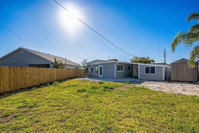 back of property with an outdoor structure, fence, a storage shed, and a lawn