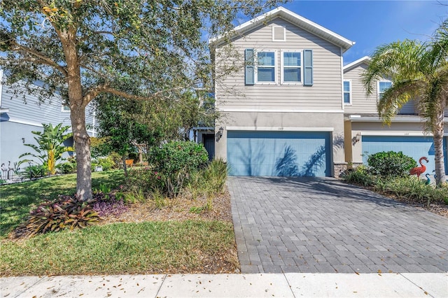 view of front of house with a garage, decorative driveway, and stucco siding