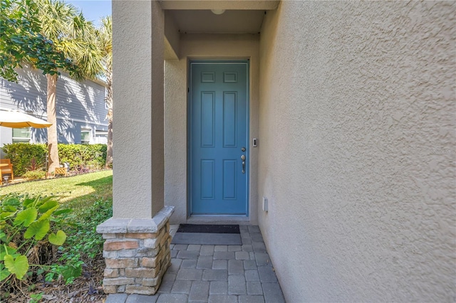 entrance to property featuring stucco siding