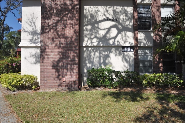 view of home's exterior with a lawn and brick siding